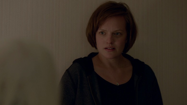 Robin Griffin standing next to a white wall on Top of the Lake S1E1