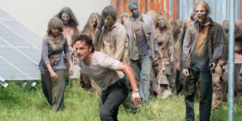 Rick Grimes preparing to fight with walkers behind him in The Walking Dead