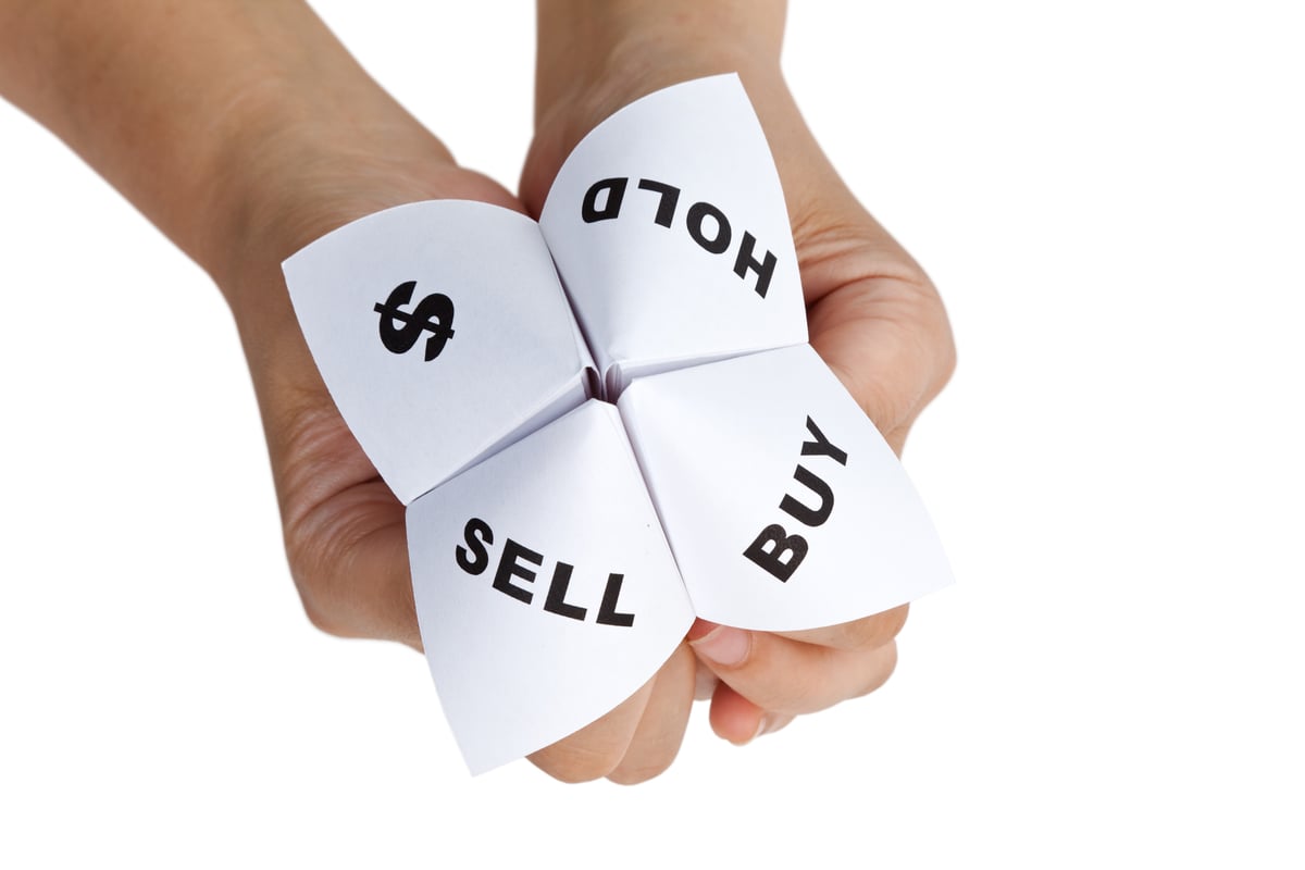 A toy fortune teller with the choices buy, sell, or hold, and a dollar sign.