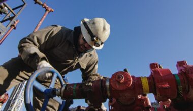 A person leaning over energy infrastructure.