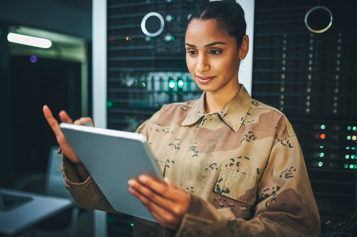 A soldier analyzes data inside a data center.