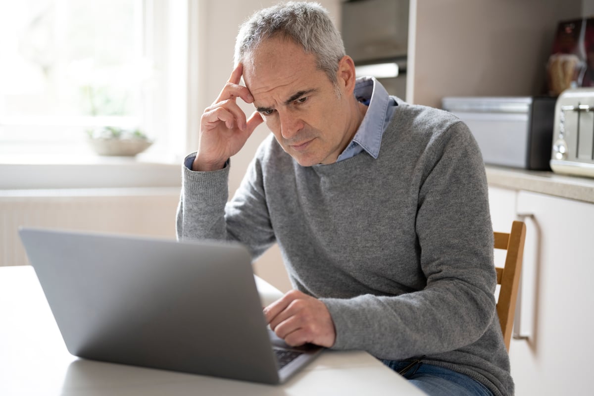 Person looking concerned while on laptop.