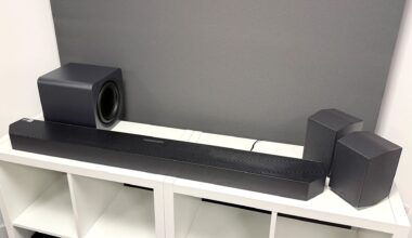 Samsung HW-Q990H soundbar package on white wooden shelf unit in front of grey baffle