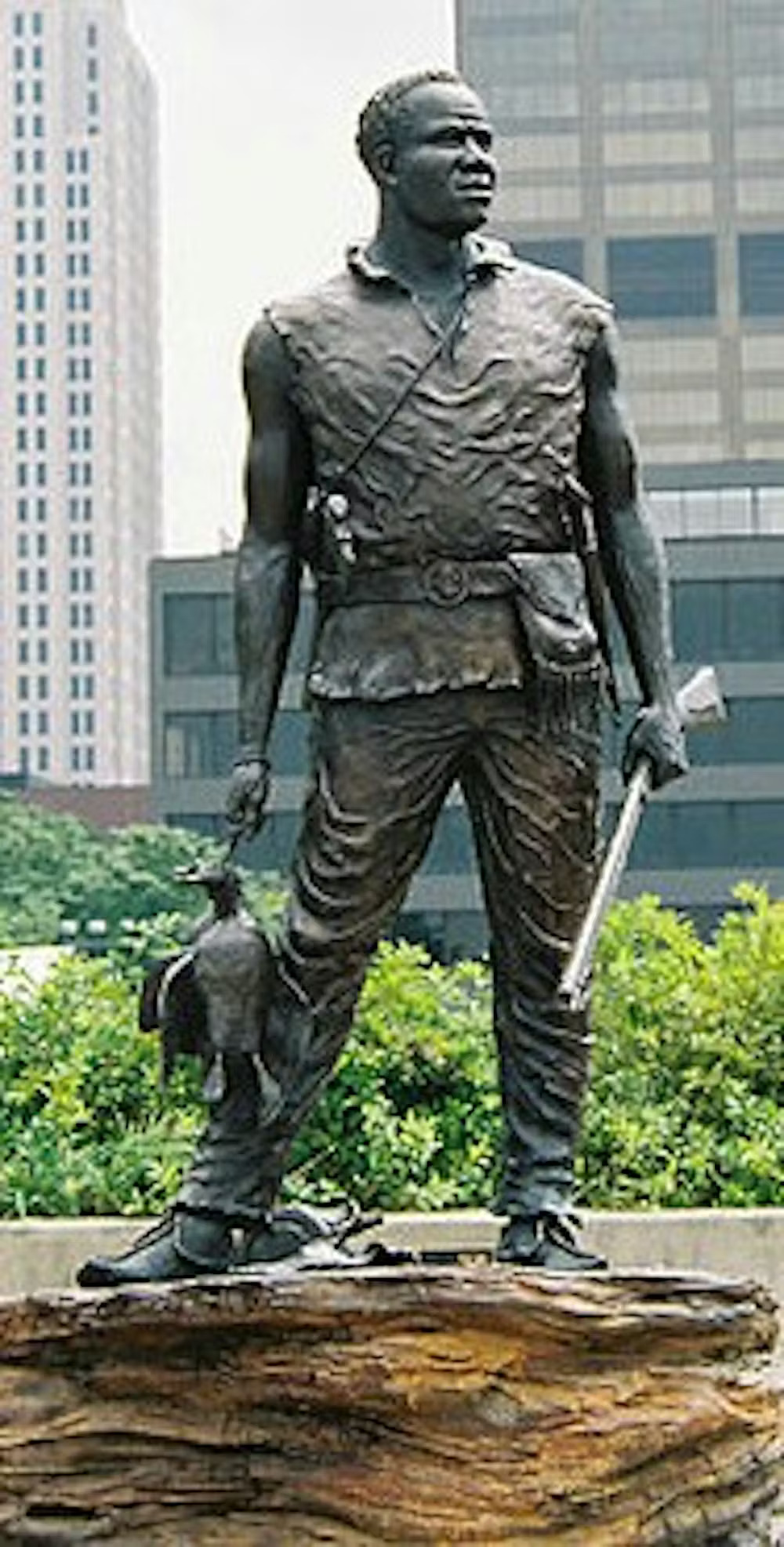 A statue of a man holding a duck and a gun.