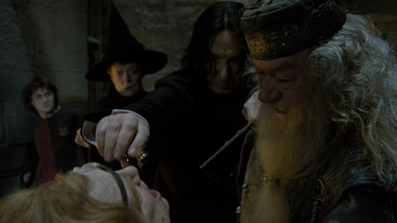 Snape (Alan Rickman) pouring Veritaserum down Moody's (Brendan Gleeson) throat while Dumbledore (Michael Gambon), McGonagall (Maggie Smith), and Harry (Daniel Radcliffe) watch in Harry Potter and the Goblet of Fire