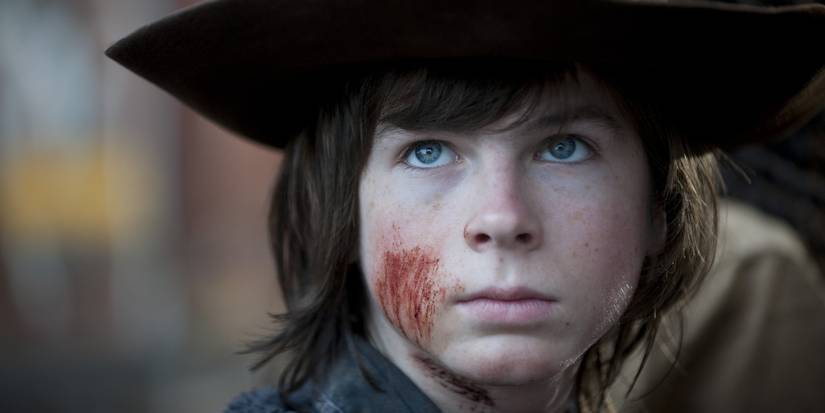 Carl Grimes with scratches on his face wearing Rick's hat in the Walking Dead