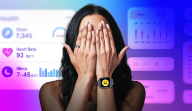 A person with hands covering their face while wearing a smartwatch and smart ring. Health notifications are going off in the background.
