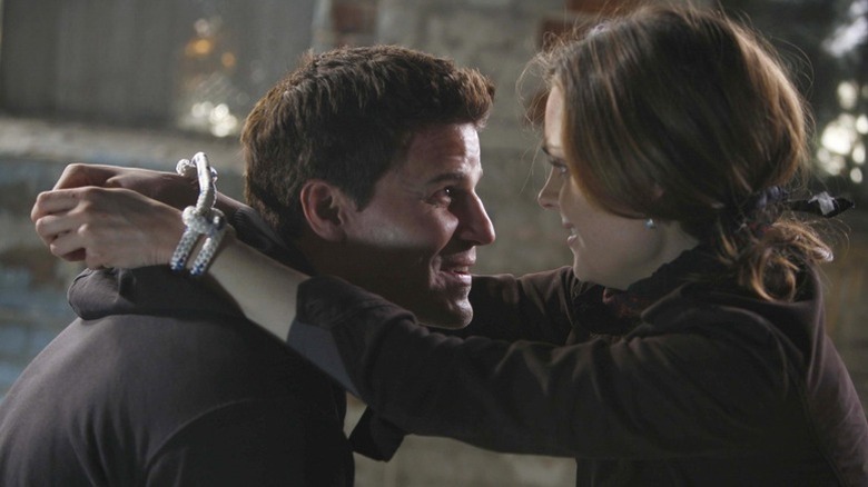 Brennan wrapping her arms around Booth
