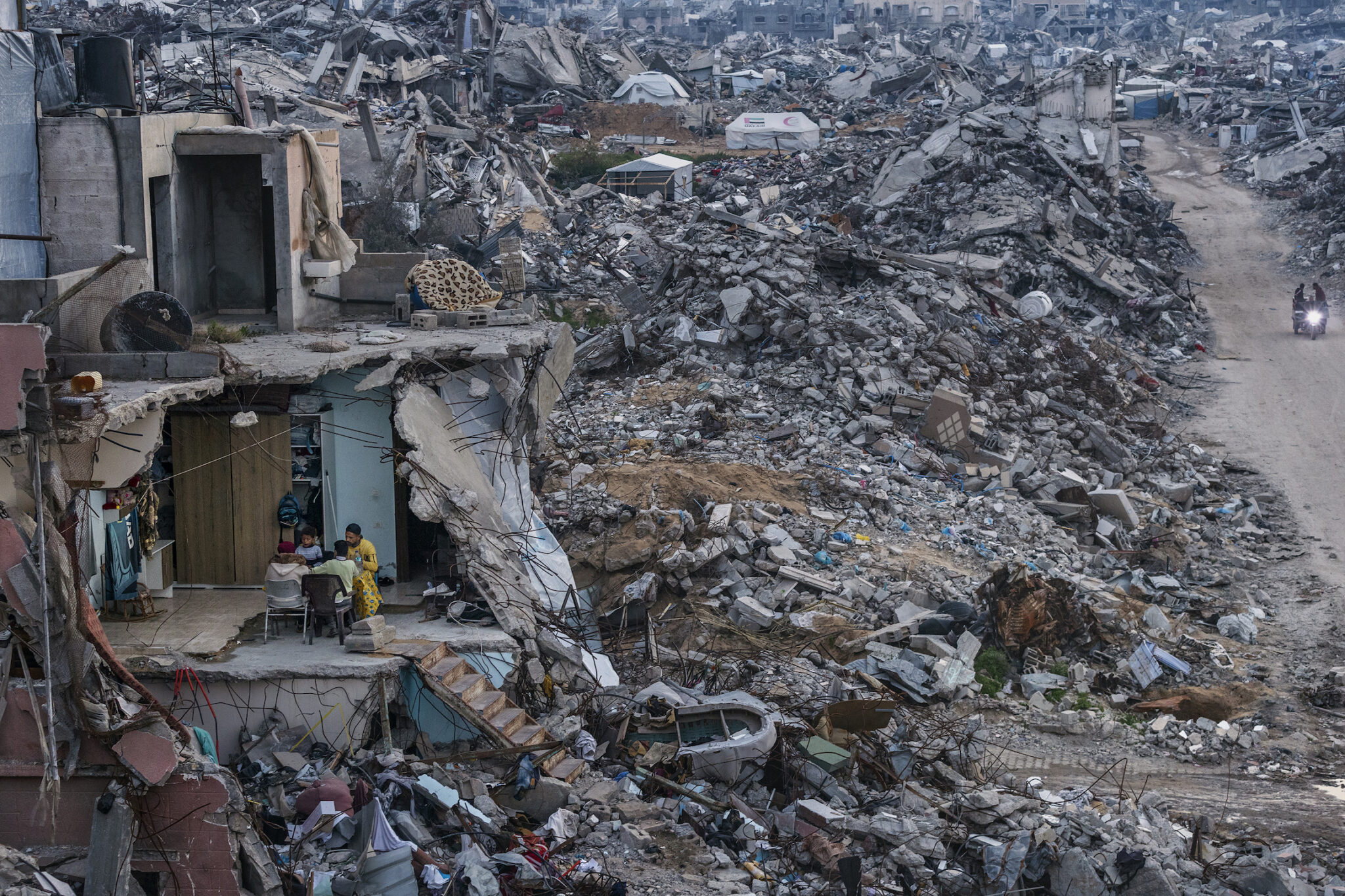 Saher Alghorra, “Witnessing Gaza,” for the New York Times. Tamer Hassan al-Shafei and his family break their Ramadan fast in the remains of their home. Food shortages meant only basics were served instead of the usual spread. Beit Lahia, Gaza Strip, March 4, 2025.