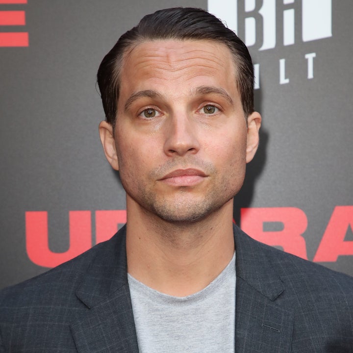 Person in a checkered suit jacket and gray t-shirt at a celebrity event