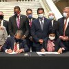 Georgia Gov. Brian Kemp, left, and Centers for Medicare and Medicaid Services Administrator Seema Verma, right, sign waivers allowing Georgia to institute work requirements for certain Medicaid recipients at the state Capitol in Atlanta, Oct. 15, 2020.