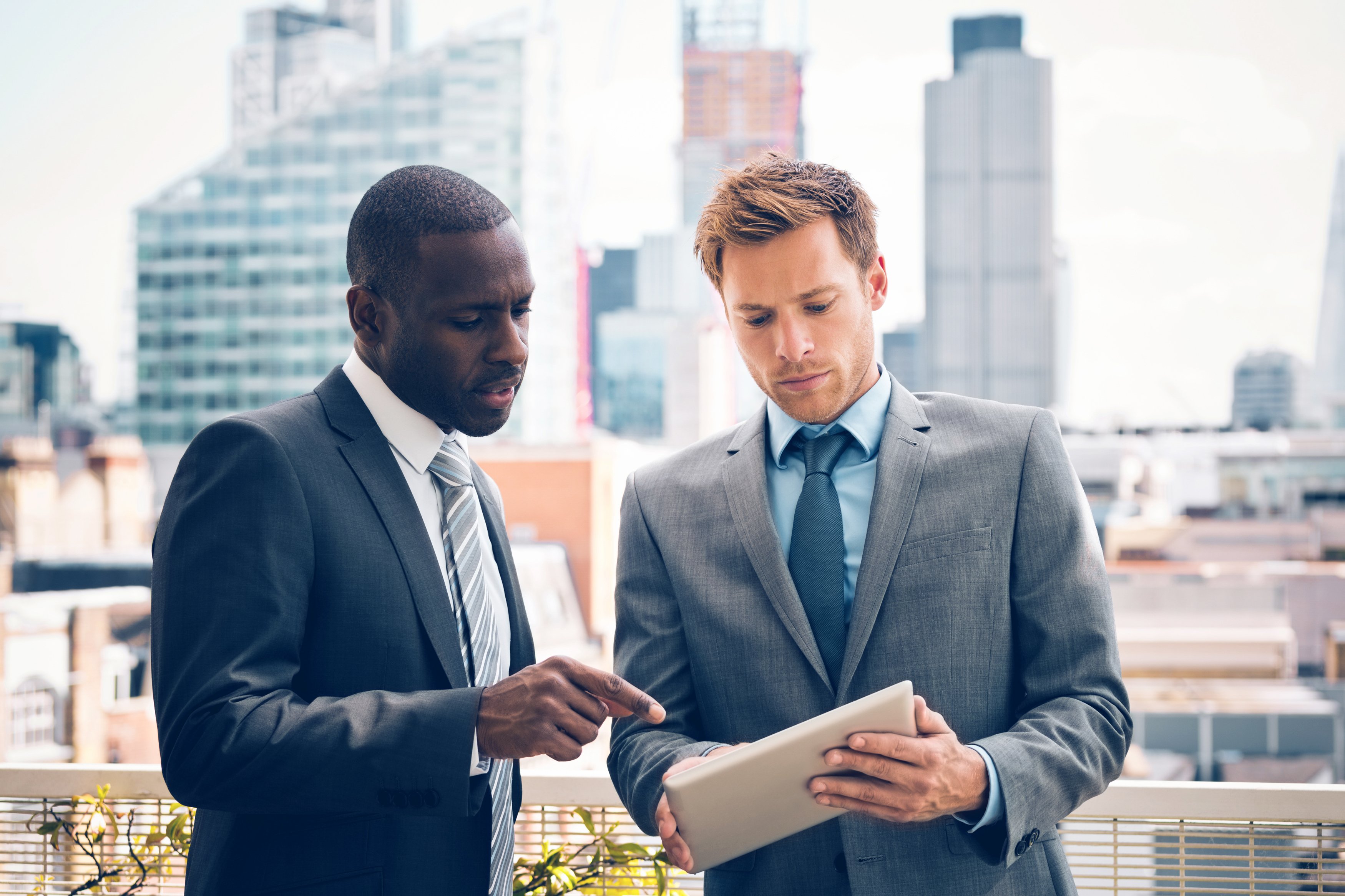 Two investors looking at a tablet.