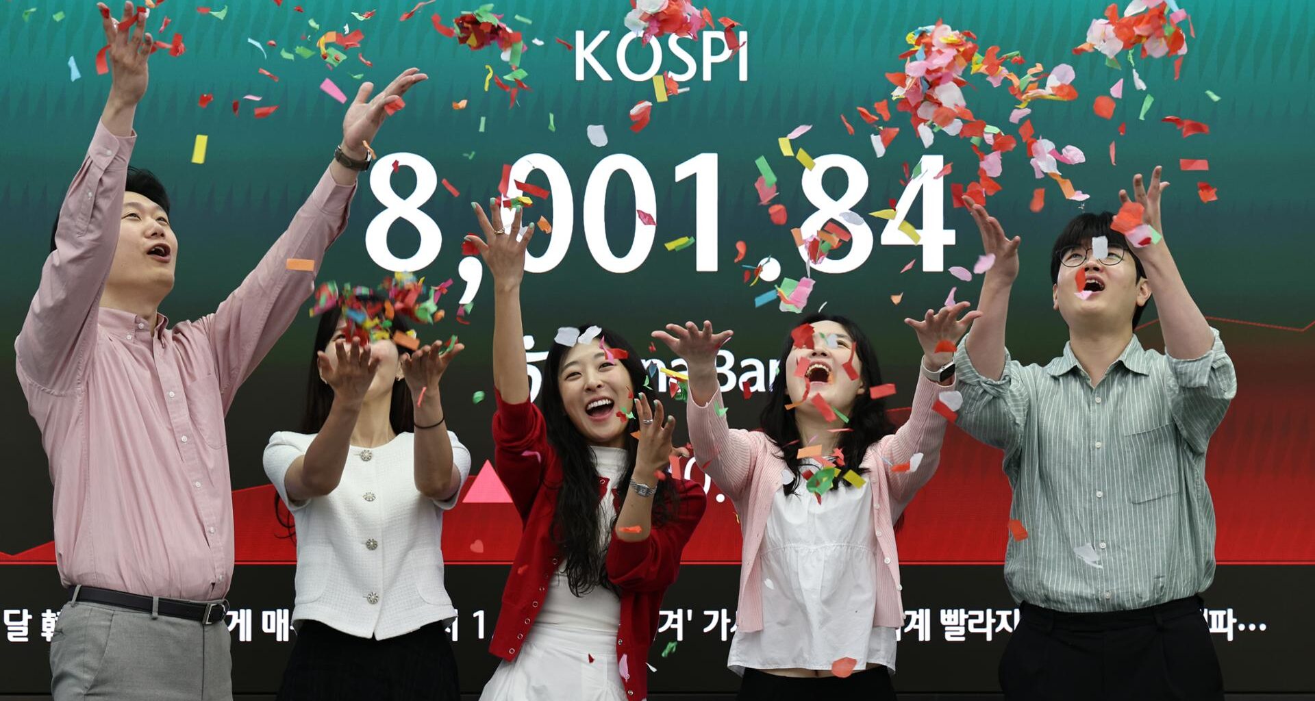 Officials celebrate KOSPI breaching the unprecedented 8,000 points mark at a dealing room in Hana Bank, Seoul, Friday. Yonhap