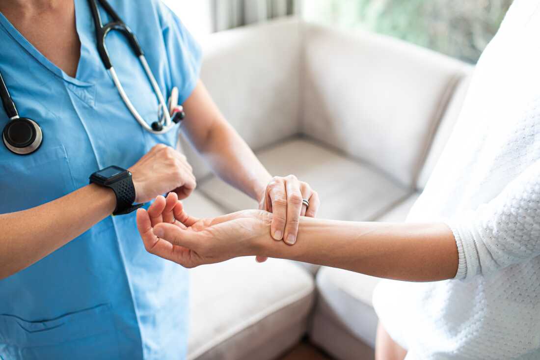 A nurse checks a patient's blood pressure.