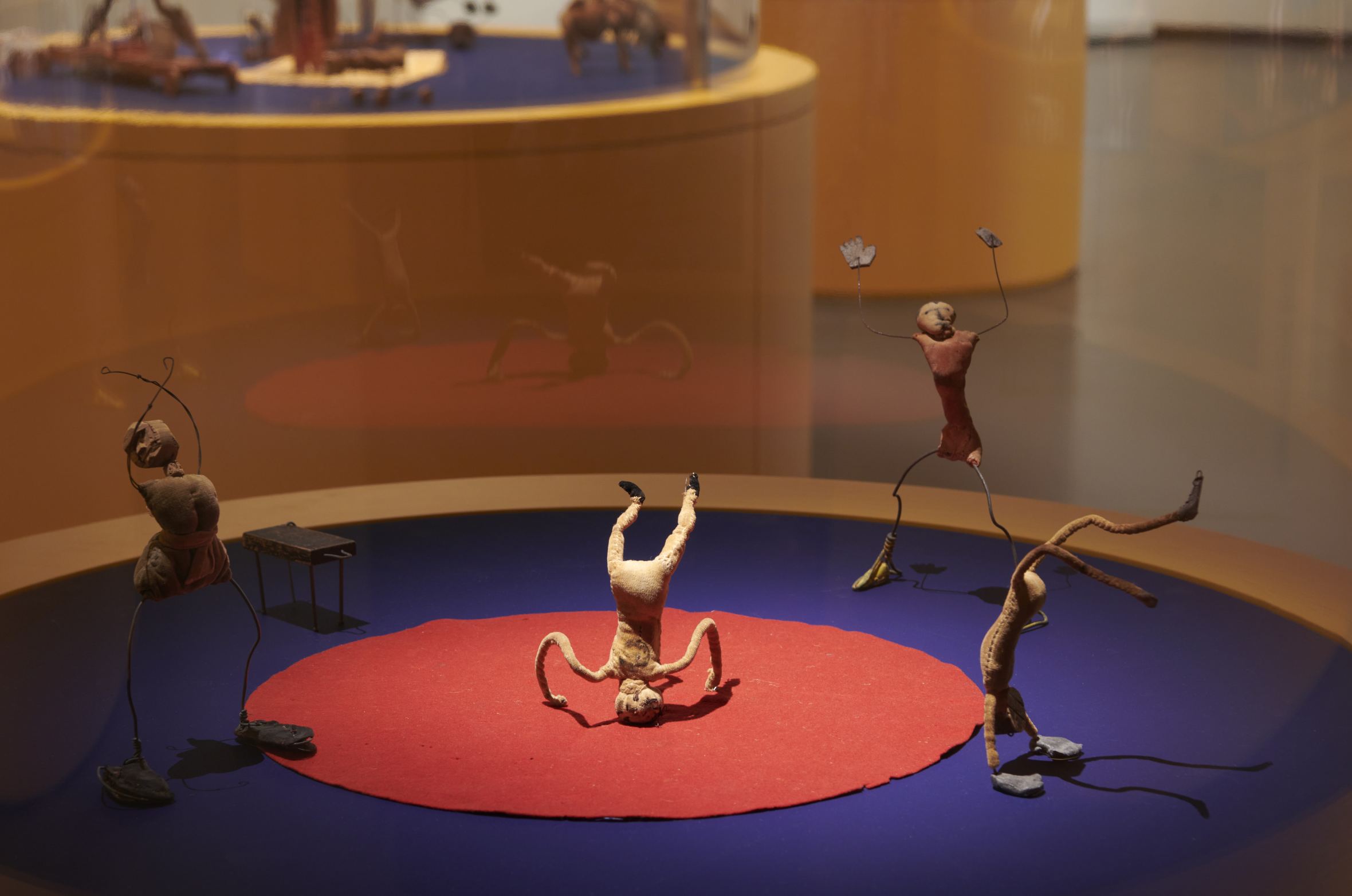 Alexander Calder's "Cirque Calder" installation with several small wire and cloth figures on red and blue platforms.