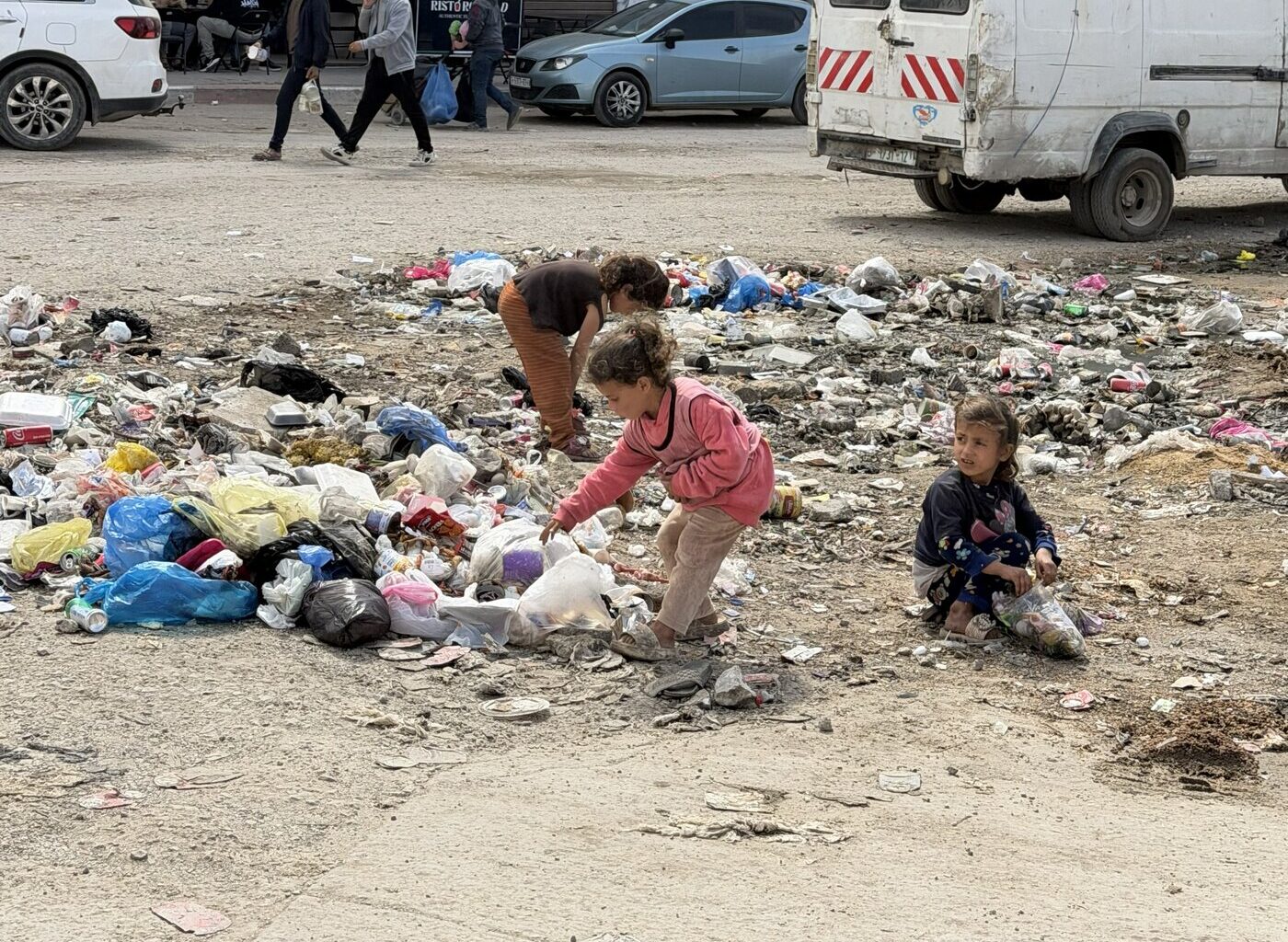 Children rummage through solid waste at a displacement site affected by pests and rodents in Gaza city