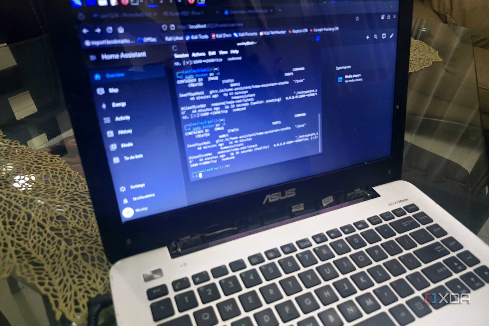 laptop displaying a Kali Linux terminal showing Docker container statuses for Home Assistant and Node-RED,