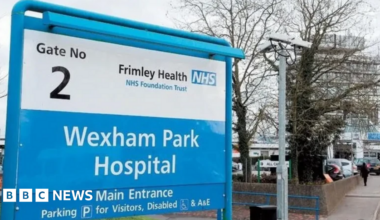 A sign outside Wexham Park Hospital and a building to the right of it.