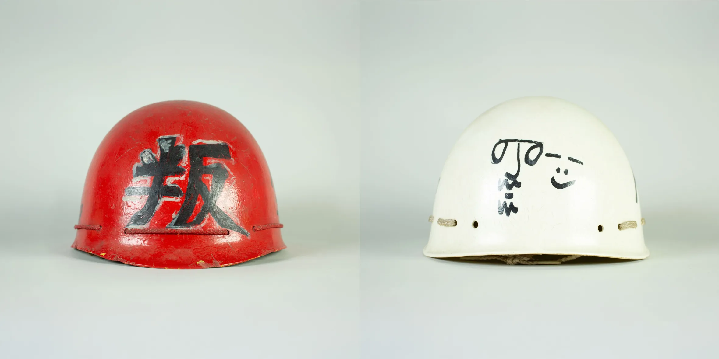 Collage of a red helmet with black Japanese characters and a white helmet with a black doodle of a face, used by the Plastic Ono Band.