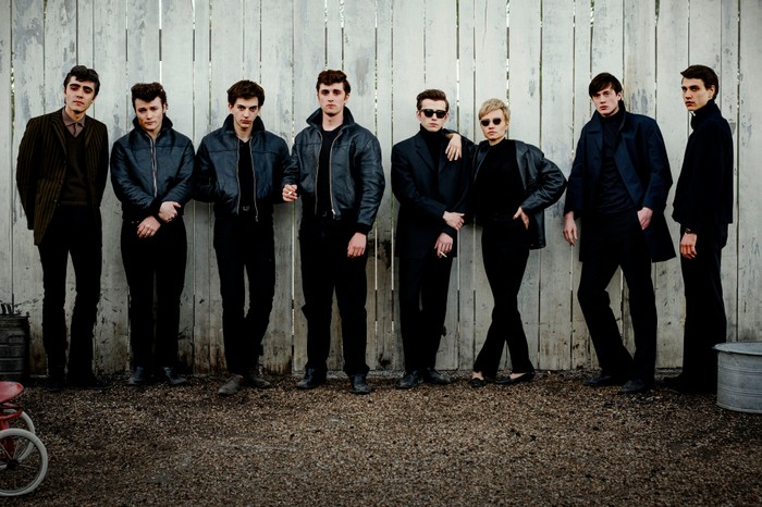 Ellis Murphy as Paul McCartney, Paddy Gilmore as Pete Best, Harvey Brett as George Harrison, Rhys Mannion as John Lennon, Louis Landau as Stuart Sutcliffe, Luna Jordan as Astrid Kirchherr, Casper von Bülow as Klaus Voormann and Lasse Klene as Jürgen Vollmer in Hamburg Days, wearing leather jackets and stood against a fence. McCartney is in a suit.