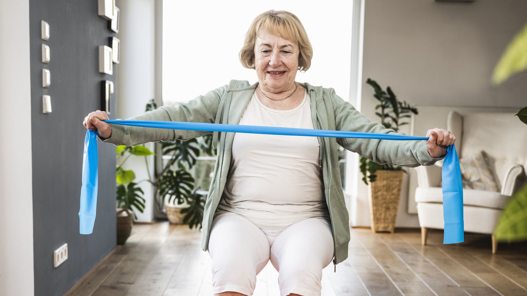 Woman exercising with resistance band in domestic setting