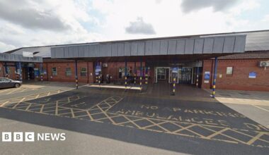 The main entrance to Bridlington Hospital. It has a grey canopy over the doors and an ambulance parking bay in front marked in yellow paint.