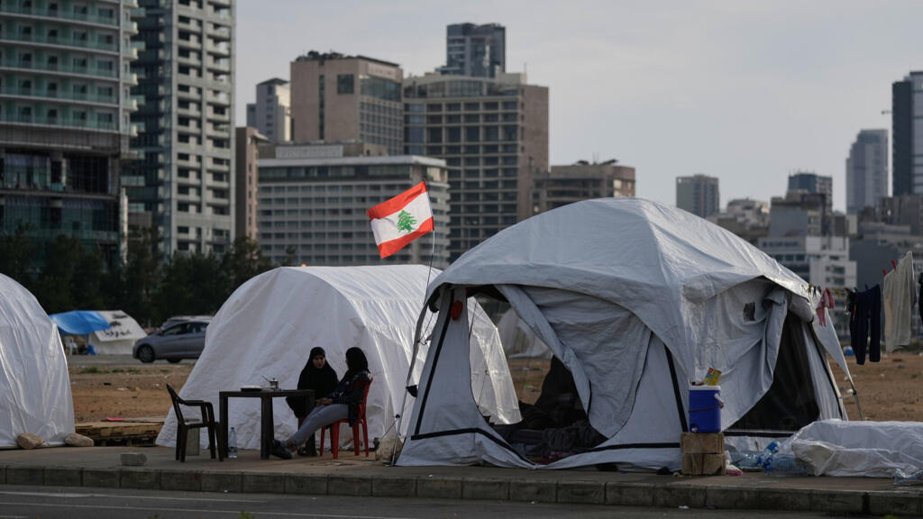 File photo of displaced people who fled Israeli strikes in southern Lebanon sit outside shelter tents in Beirut, April 24, 2026.