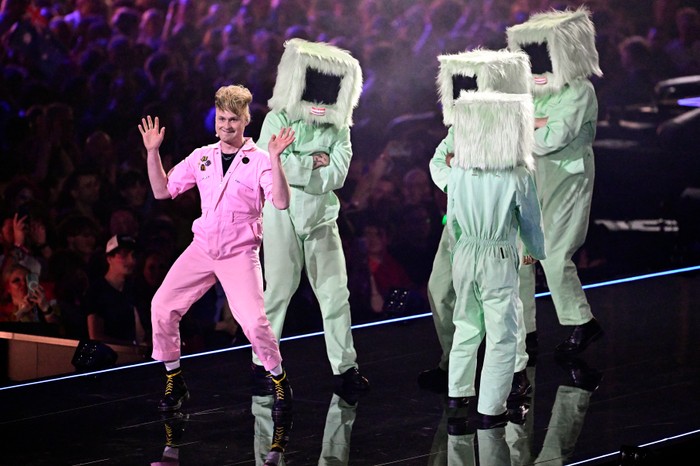 AUSTRIA-ENTERTAINMENT-MUSIC-TELEVISION-ESC Sam Battle, aka Look Mum No Computer wearing a pink boiler suit stood on stage with his hands in he air.