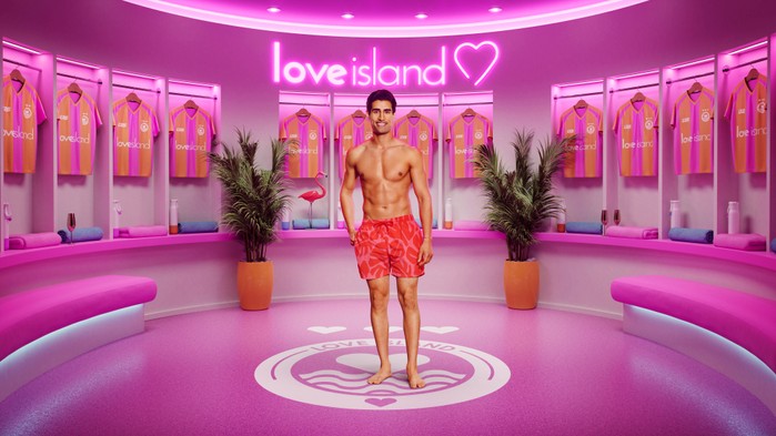 ©ITV Samraj stood smiling wearing orange swim shorts.