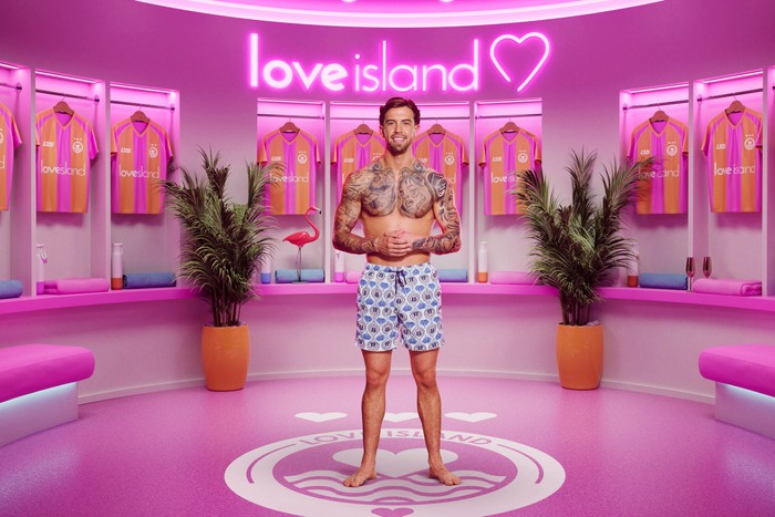 Aidan. Aidan in front of a pink Love Island 2026 background.