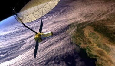 Artist's concept depicts the NASA-ISRO Synthetic Aperture Radar with a main satellite body having two solar panels and a boom attached to the large antenna reflector. The Earth below shows clouds covering the coast of California and the Pacific Ocean.