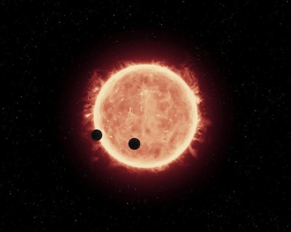 This illustration shows the red dwarf star TRAPPIST-1 and two of its rocky planets. Researchers detected several red dwarfs just like it that have appeared to have eaten their planets, though TRAPPIST-1 isn't one of them. Planetary engulfment is a rare yet possible outcome of normal planetary system evolution. Image Credit: ESA/Hubble. Licence Type: Attribution (CC BY 4.0)