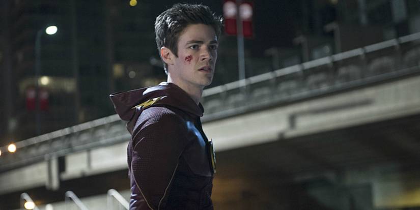 Barry Allen looks angry with cuts on his face while wearing his Flash costume in The Flash episode The Man In The Yellow Suit
