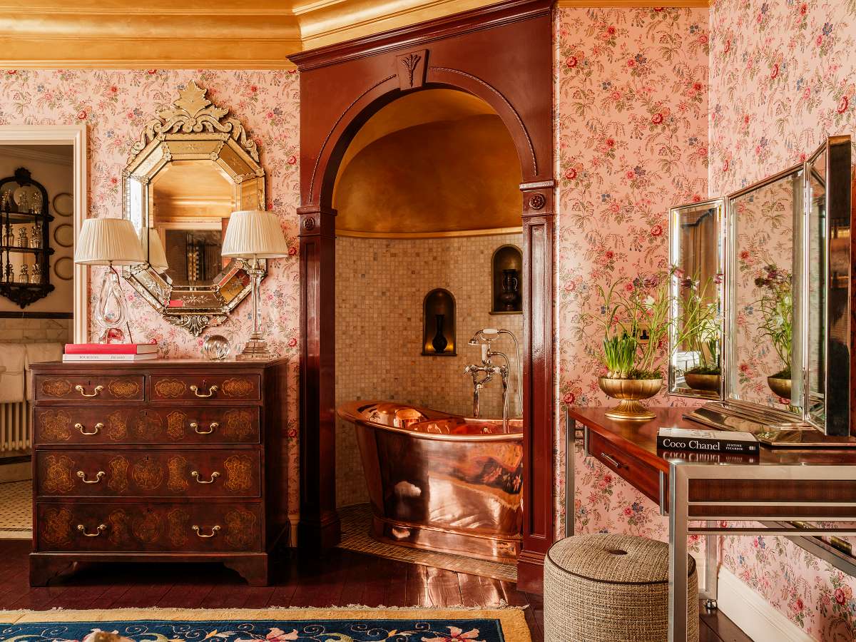 guestroom in Fife Arms with copper bathtub in recess , floral wallpaper and period furniture