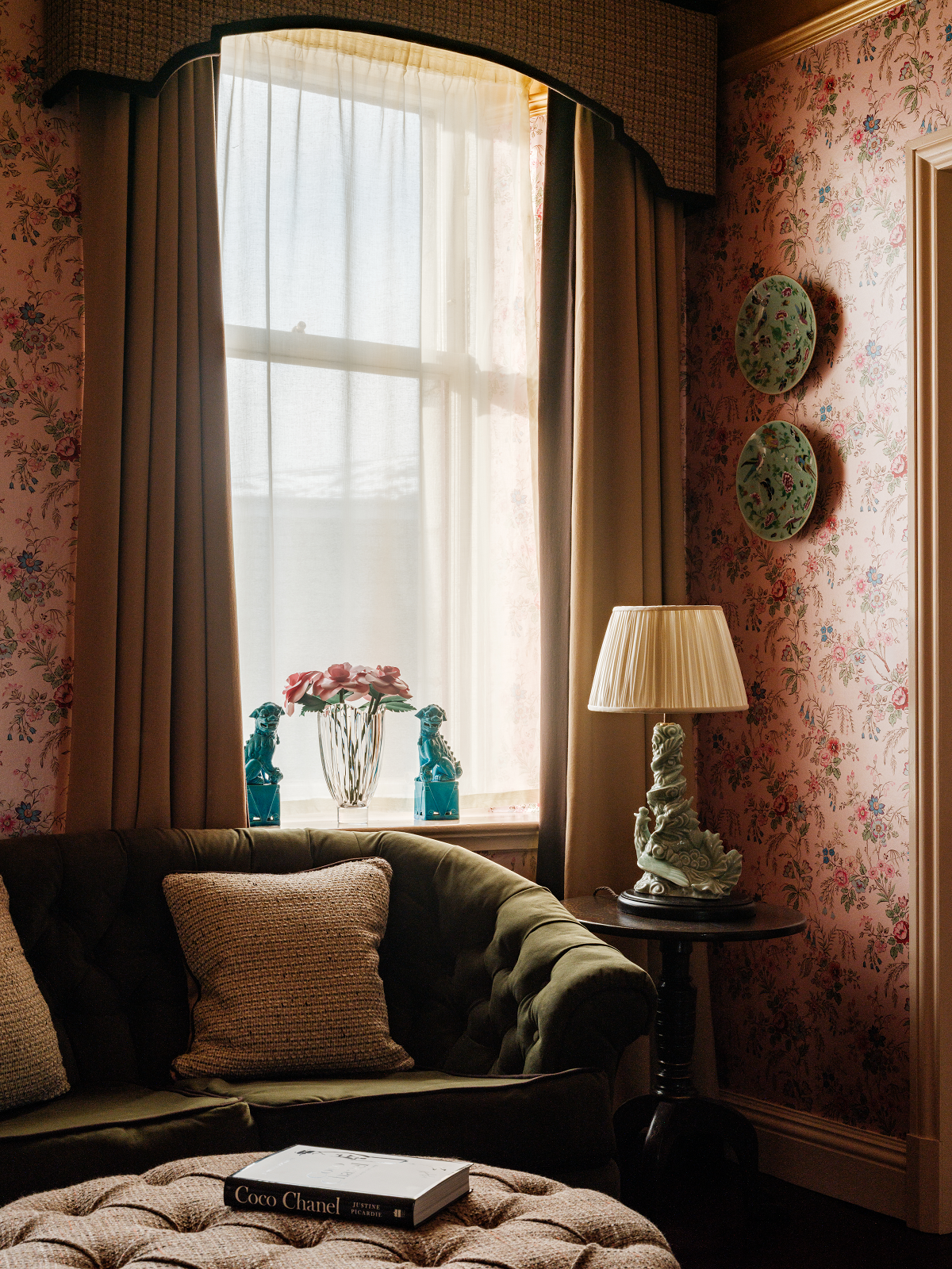window surrounded by floral wallpaper with antique lamp and couch