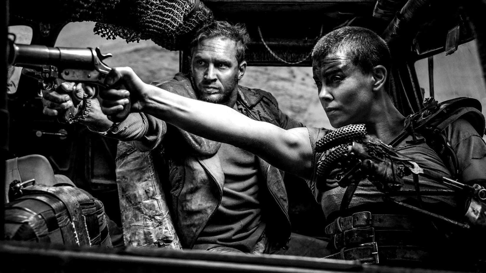 a still from mad max fury road black and chrome showing max and furiosa