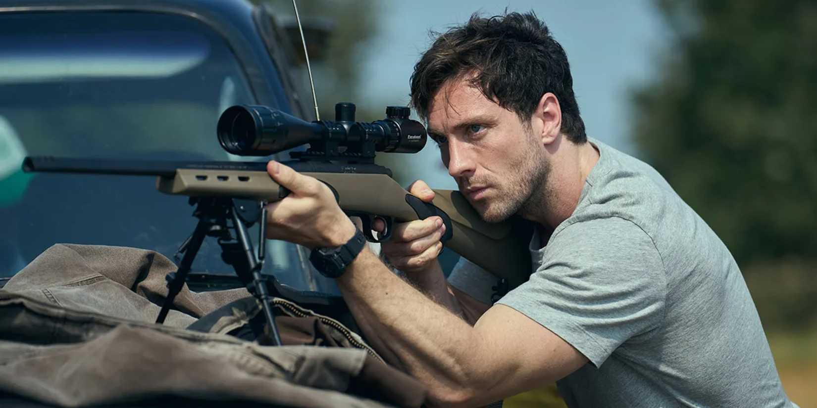 Aaron Taylor Johnson aims a sniper rifle over the hood of a truck in Fuze