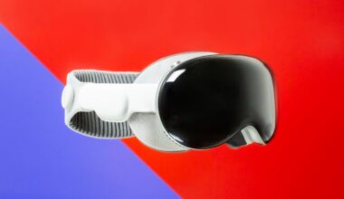 Apple Vision Pro AR/VR headset is shown on a split background of purple and red.