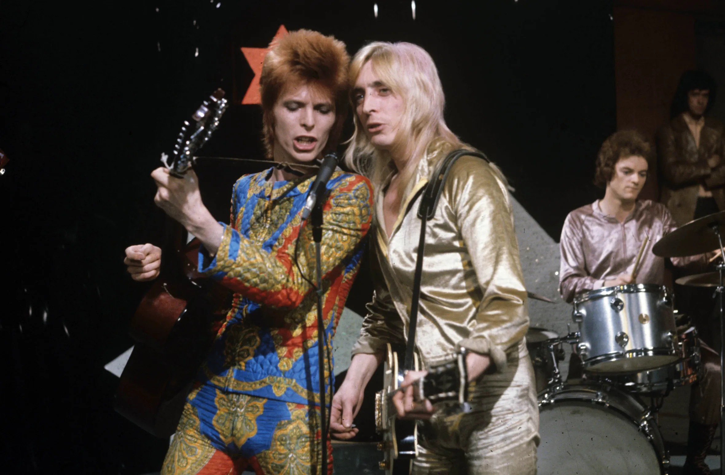David Bowie and Mick Ronson performing on stage.