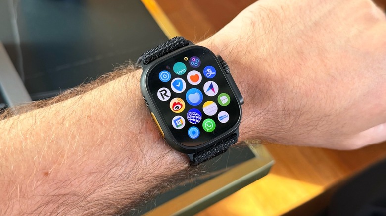 A man wearing an Apple Watch showing the apps on the App Library