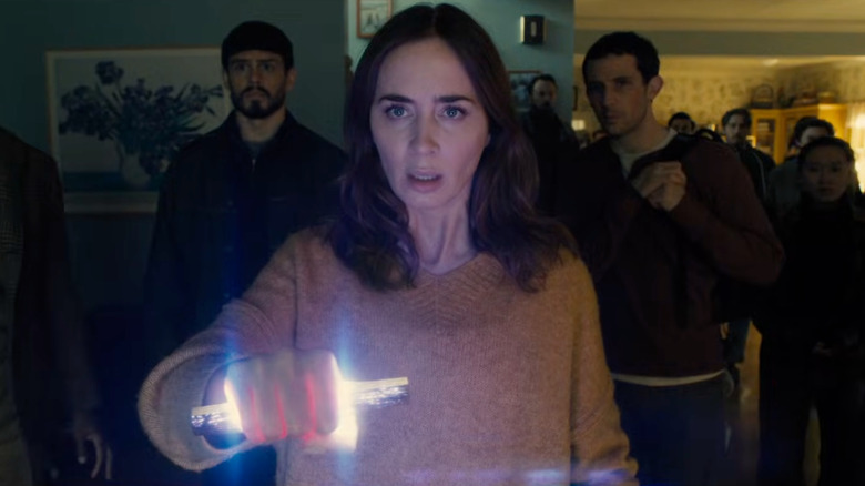 Margaret holding a glowing object and looking scared in Disclosure Day