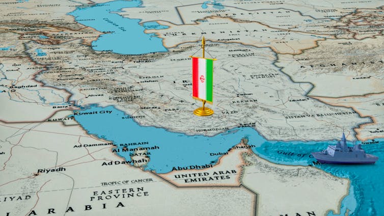 Map of Middle  East with Iranian flag and model warship.
