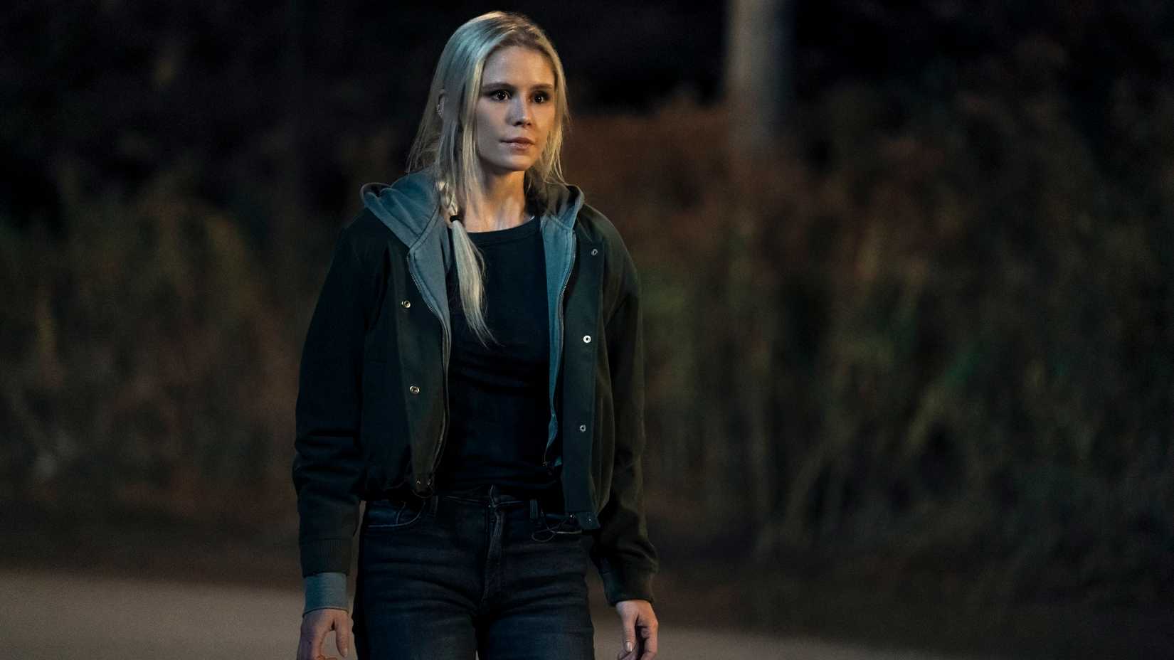 Starlight (Erin Moriarty) wearing jeans and a hoodie stands in the road in Gen V.