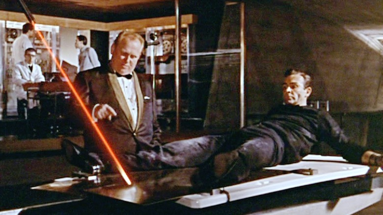 James Bond on the table as Goldfinger explains the laser in 