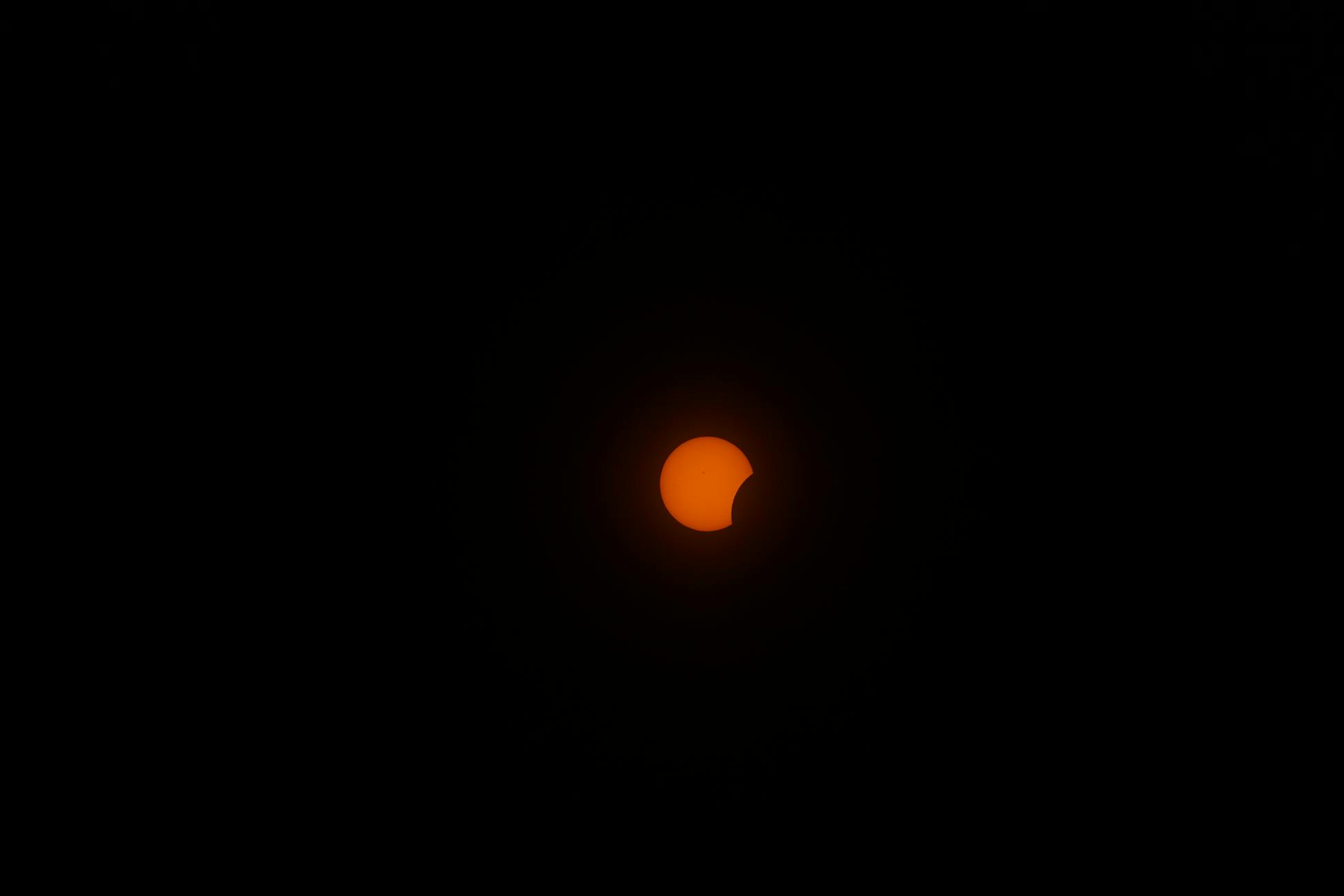 Capture of a solar eclipse with the moon partially covering the sun at night.