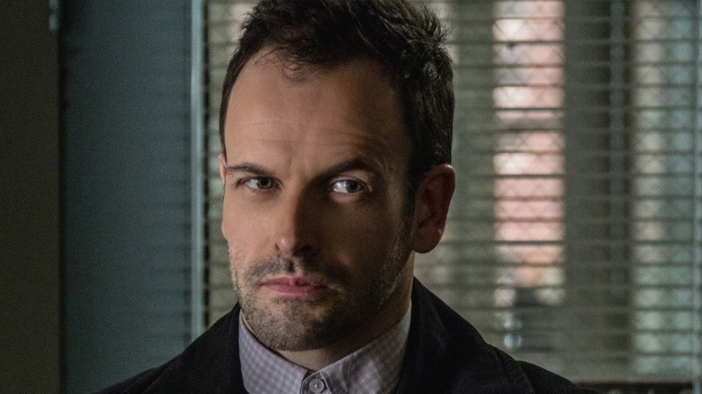 Sherlock Holmes (Jonny Lee Miller) glances warily in Elementary