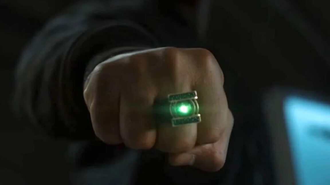 hand clenched in a fist with a glowing green ring on one finger