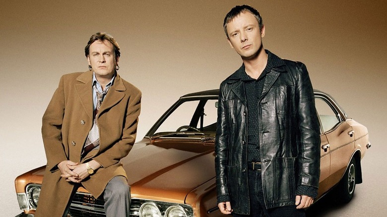 Gene and Sam next to a car, frowning, in 