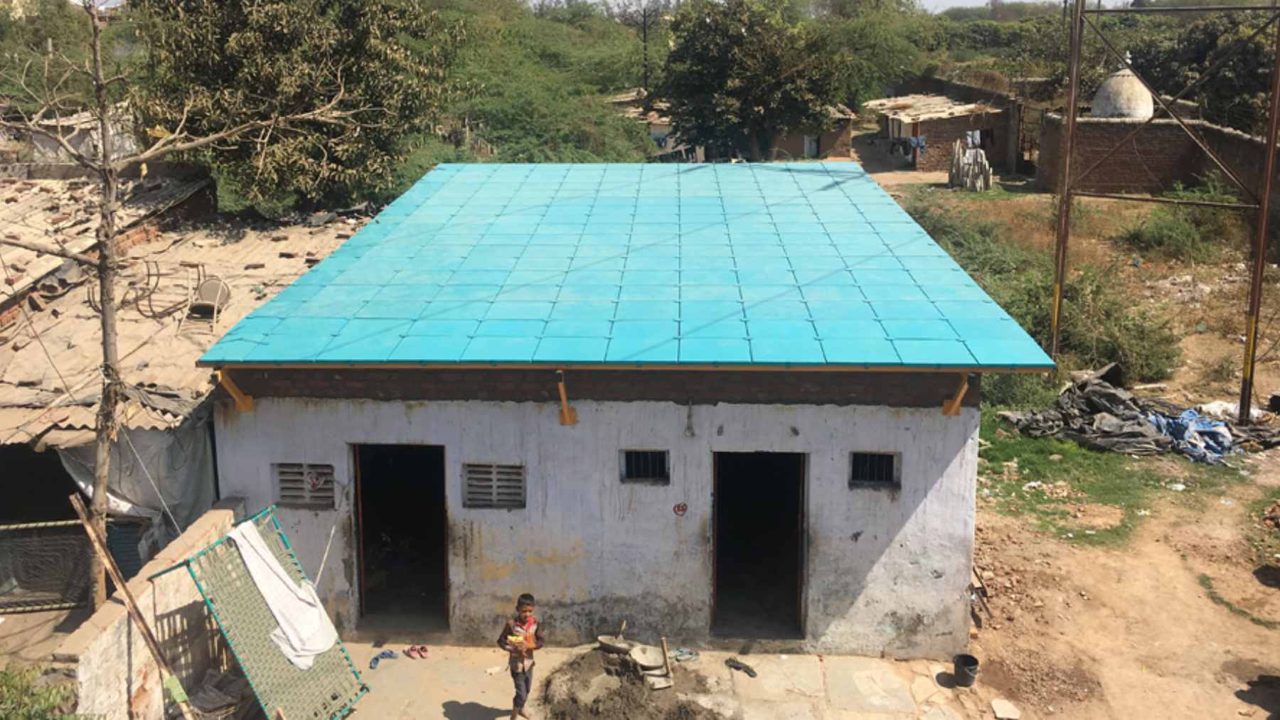 ModRoof modular panels made from recycled cardboard and coconut husk fiber being installed on a low-income home.