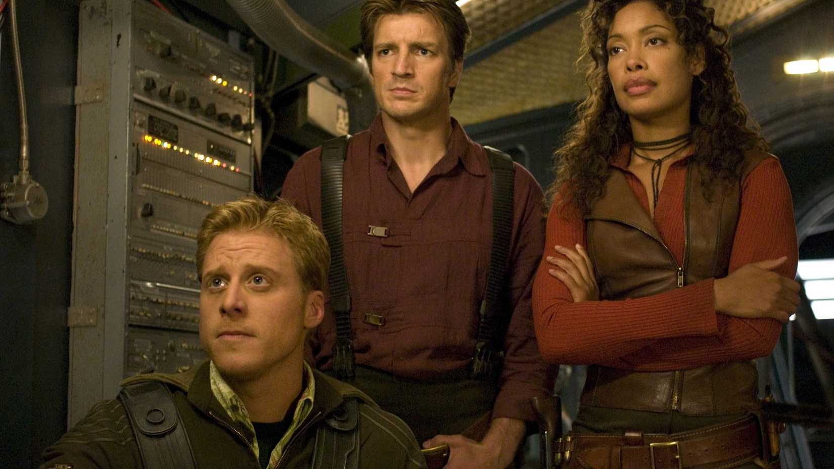 Nathan Fillion as Mal standing with Gina Torres as Zoe and behind Alan Tudyk as Wash in Serenity